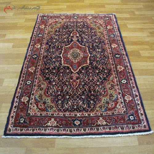 فرش دستبافت سنقر در طرح ماهی و ترنج بافته شده با الیاف طبیعی کد 39981 با زمینه ی سرمه ای و حاشیه های لاکی - هنرظریف